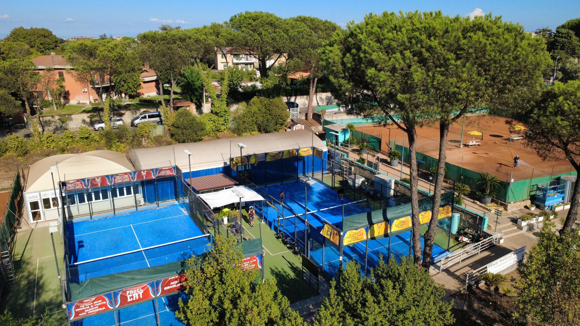 Vista dall'alto dei due campi da padel, con i campi da tennis e il verde intorno