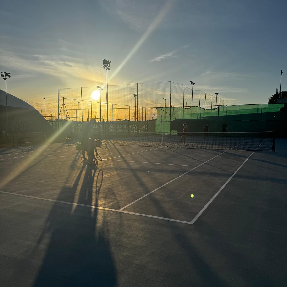 Il campo in resina al tramonto, con il sole tra i fari